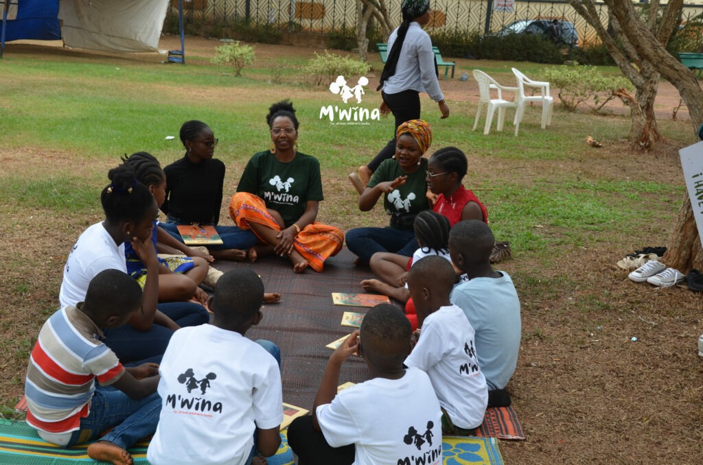 Nadine Mekougoum (dame avec le foulard sur la tête) et les participants au  "M'wina Children's Book Club". Crédit : M'wina Initiatives