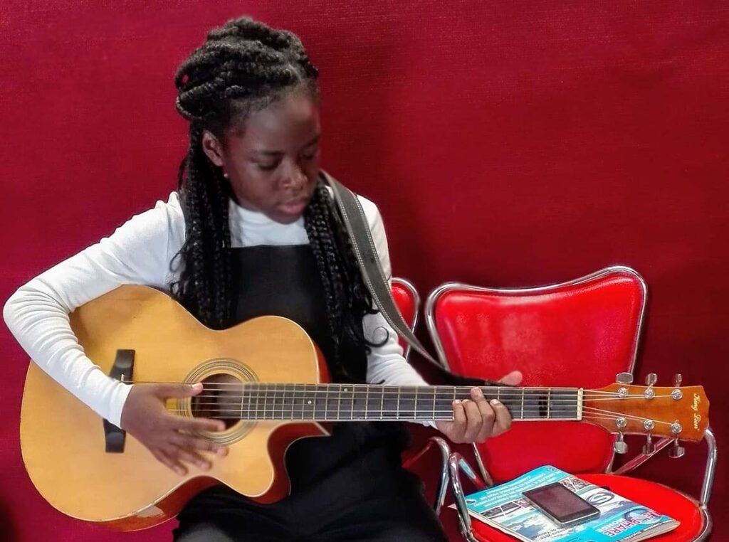 Lina Martina ADIA joue de la guitare. 