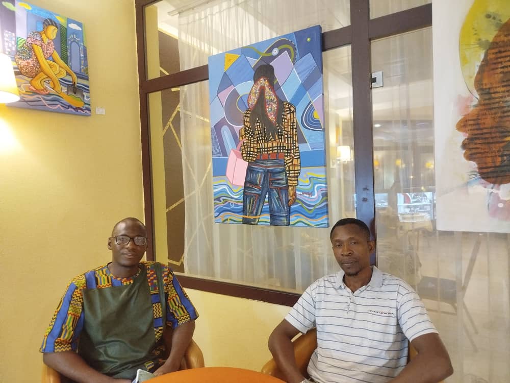 Sidoine FEUGUI et Raoul Wansi  sous son tableau. Crédit : Armelle LOBE